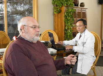 Dr. Zhou performing a hearing test in a patient's home