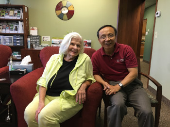 Dr. Jerry Zhou poses for a photo with a patient in his office