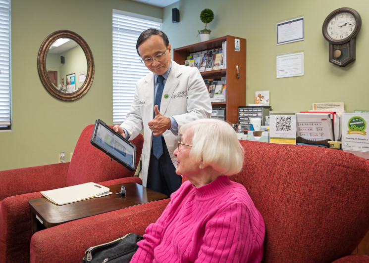 Jerry Zhou, Ph.D. consulting with a female patient
