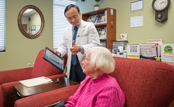 Jerry Zhou speaking with a female patient