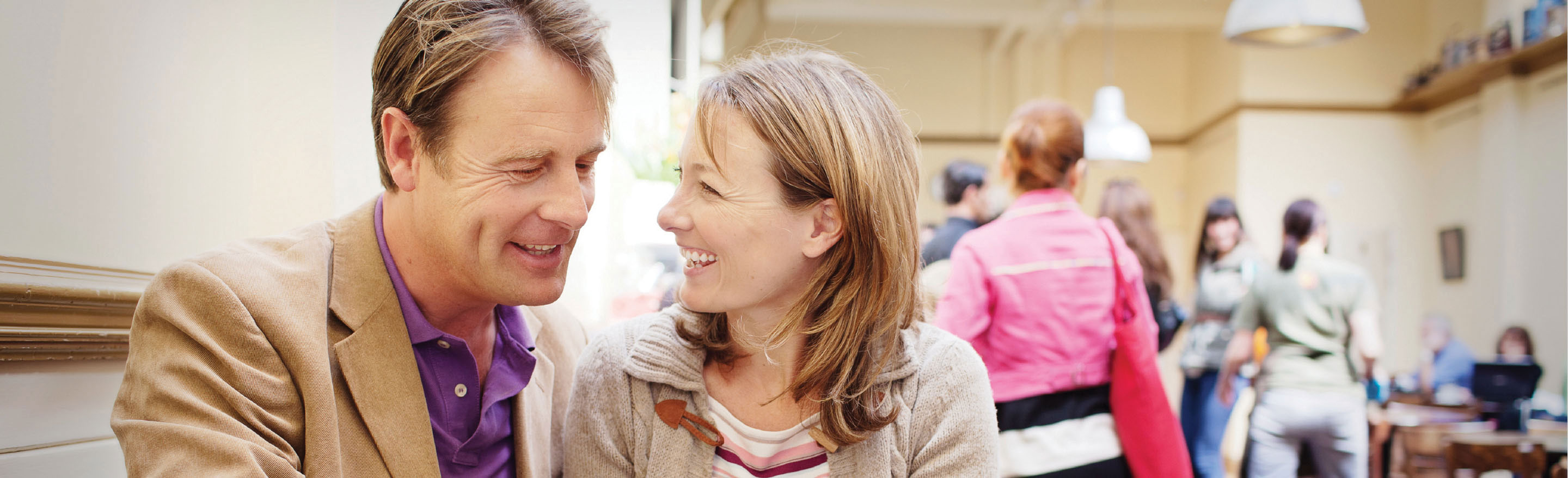 A middle aged Caucasian couple smiling in a cafe